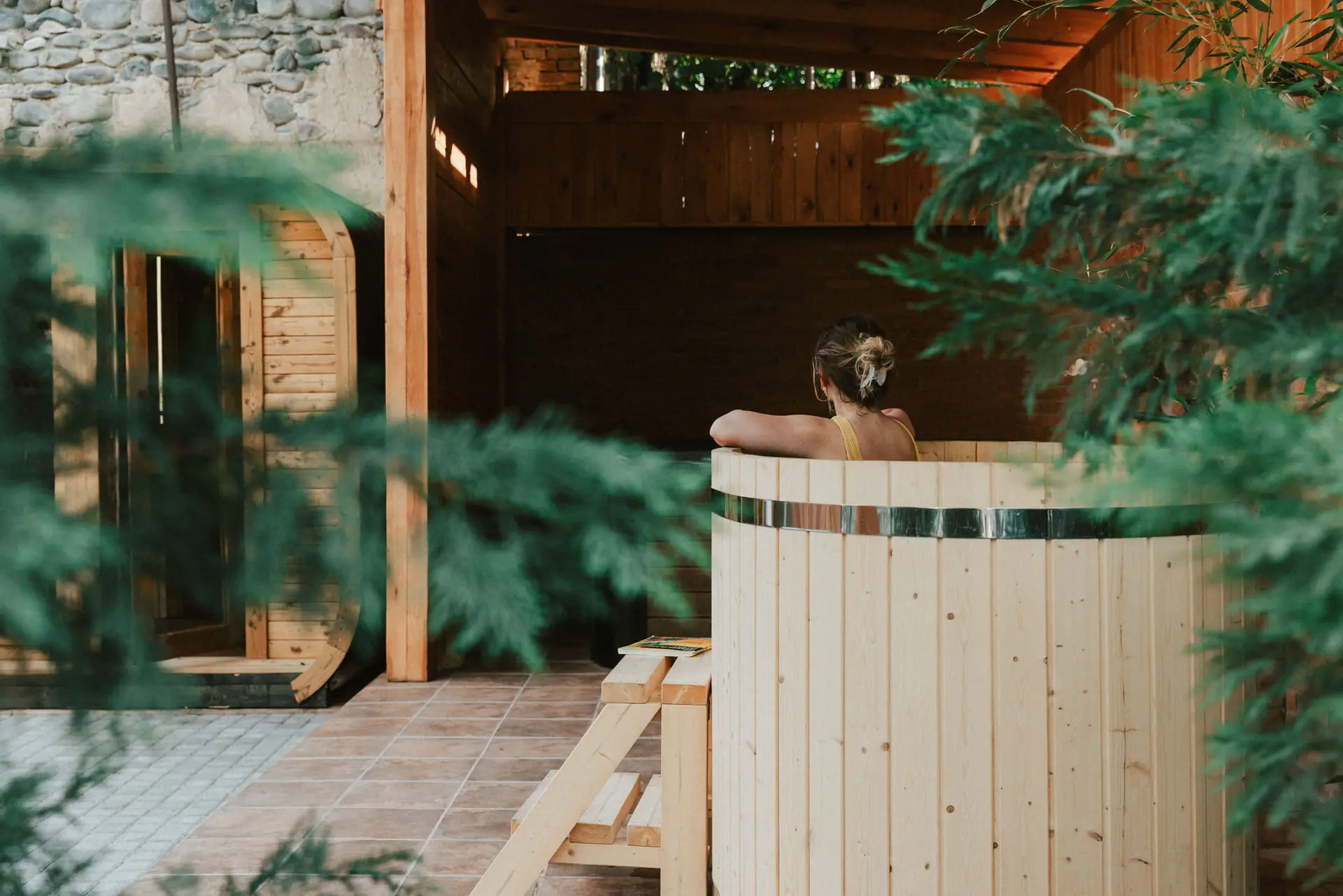 A guest in the cedar cold plunge among the bamboo