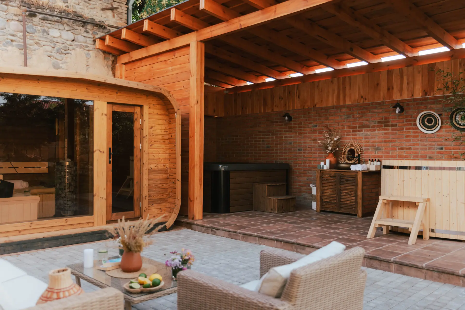 The spa with the sauna, the jacuzzi and armchairs under a wooden roof