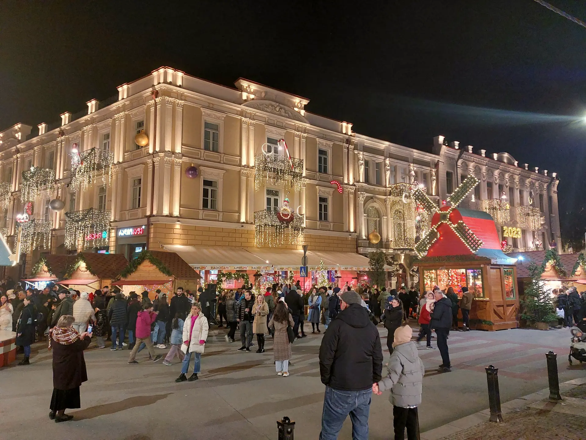 The New Year market on Atoneli Street in Tbilisi at night, by an old building hung with lights