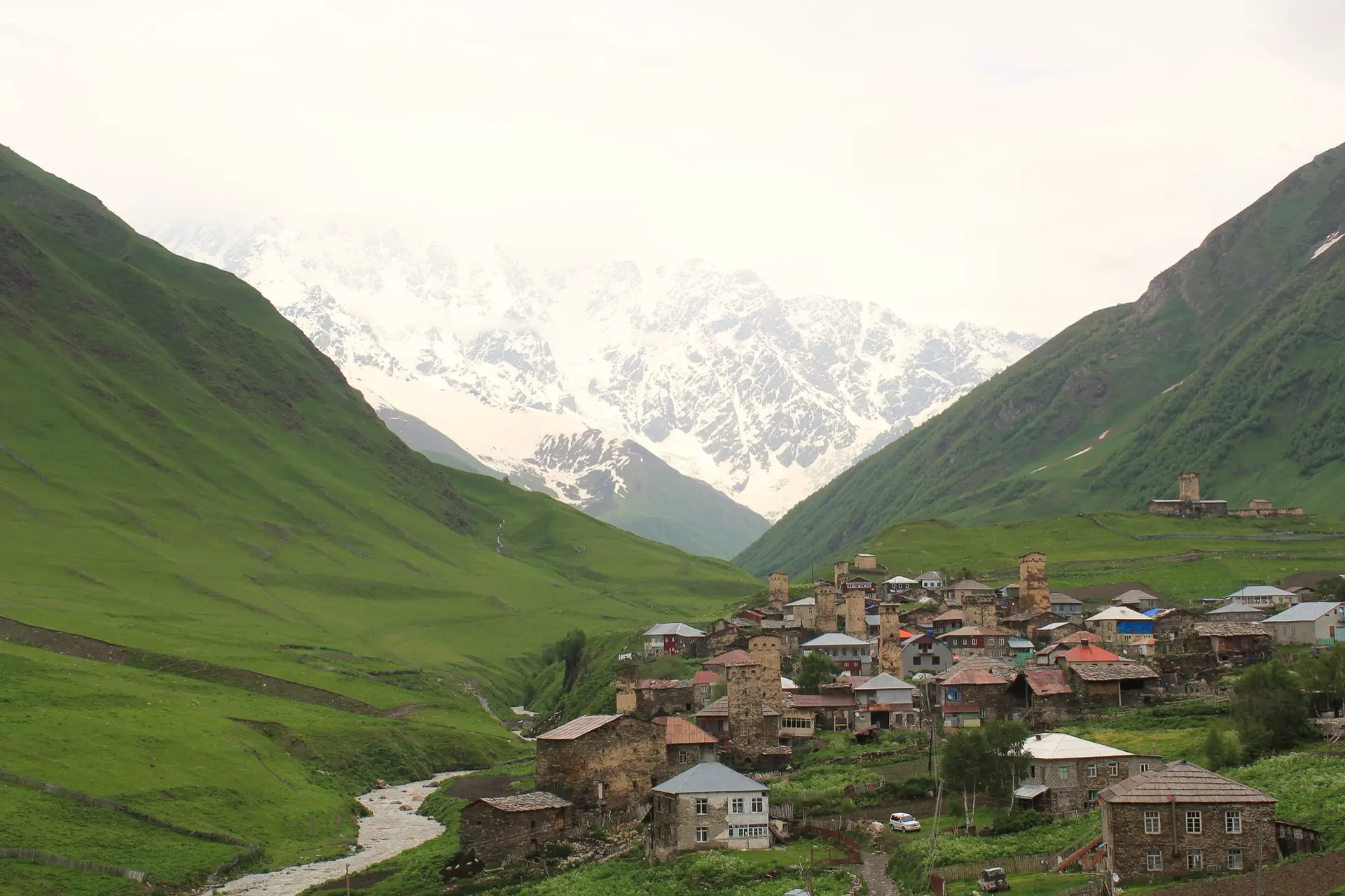 Svan towers in Ushguli with the Caucasus mountains behind