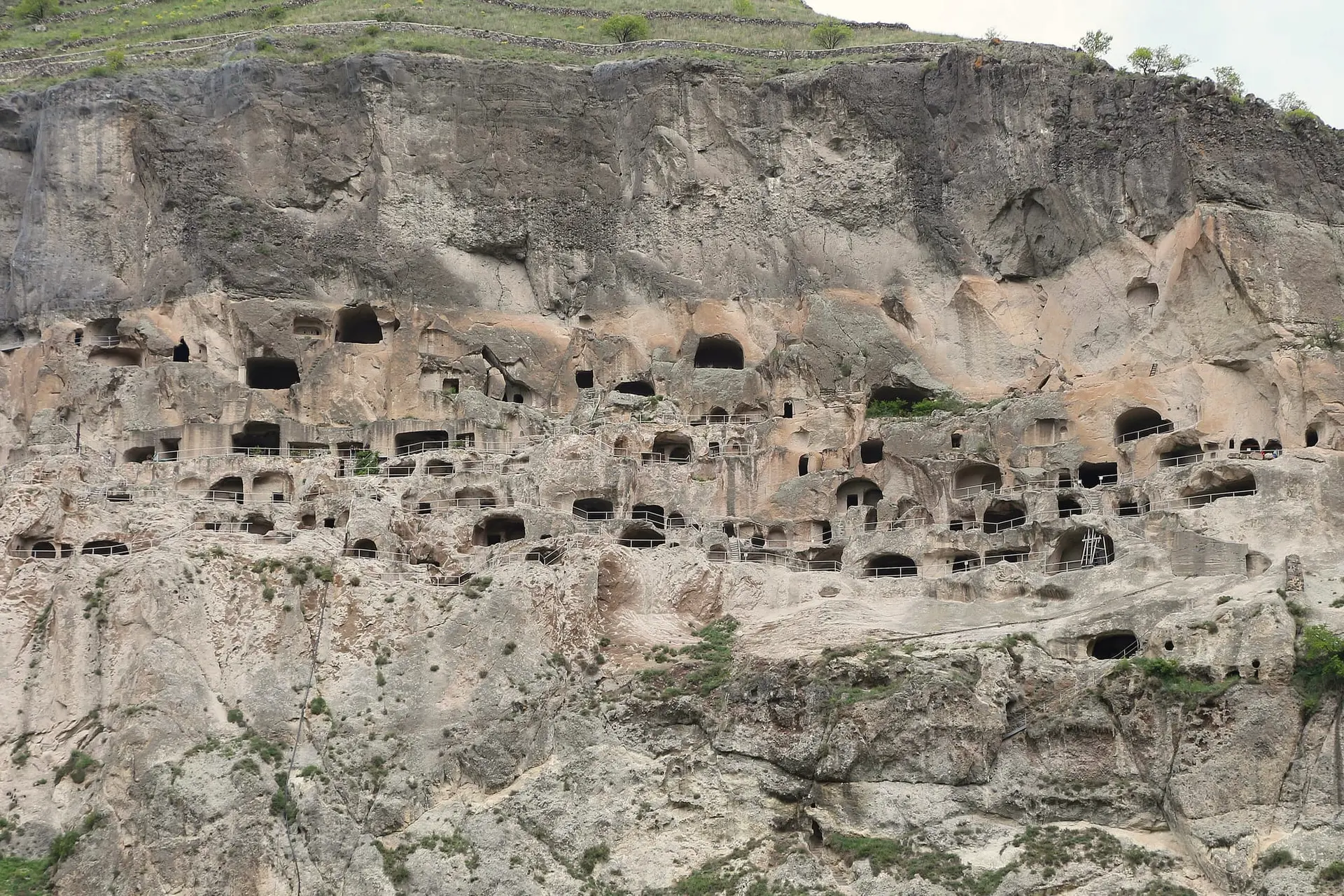 Tiers of caves at Vardzia with railings along the cliff face